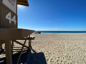 Ein Strand mit einem Rettungsturm und einer Holzbank.