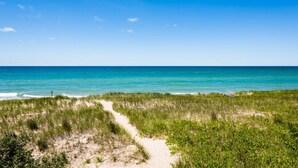 A beach path leading to the ocean with clear skies. - 2027 NOW OPEN!  Colossal Lakefront Home in Sawyer! (Sawyer)