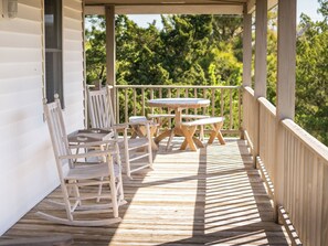 A wooden deck with a table and chairs, surrounded by a railing. - Myrtlewood: Dog friendly, island views from the rooftop lookout. (Ocracoke)