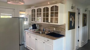 A kitchen with white cabinets, a built-in microwave, and a coffee maker. - 4 BR. 2 BTH, HOT TUB, MINS TO JONES BEACH, MINS TO RIVIERA WALK TO TRAIN TO NYC (Massapequa)