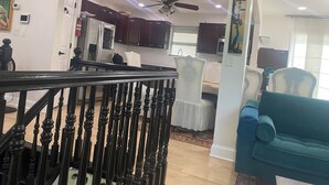 A modern kitchen with dark cabinets, a white refrigerator, and a ceiling fan. - 4 BR. 2 BTH, HOT TUB, MINS TO JONES BEACH, MINS TO RIVIERA WALK TO TRAIN TO NYC (Massapequa)
