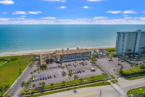 Ein Hotel mit Parkplatz, Pool und Blick auf Strand und Meer.