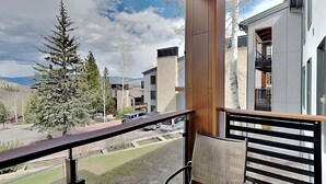 A balcony with a view of a modern building, a tree, and a street. - 🌲Timberline B2B Standard 1-Bedroom ~Hot Tub~Pool~WiFi~Ski-in/out~Local Shuttle🌲 (Snowmass Village)