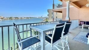 Ein Balkon mit Tisch und Stühlen mit Blick auf das Wasser.