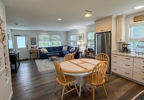 Eine moderne Küche mit Essbereich, Holzstühlen und einem blauen Sofa.