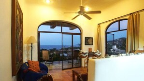 A room with a large arched window, a ceiling fan, and a view of the ocean. - Private Dipping Pool. Ocean Views. (Casita #4) (Sayulita)