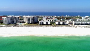 A coastal hotel with multiple buildings, a beach, and a view of the ocean. - 🏖️Beautiful 2 BR / 2BTH Beachfront Condo with Community Swimming Pool! (Pensacola Beach)
