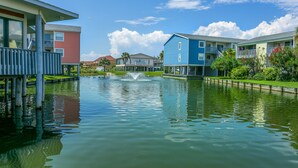 A waterfront hotel with a central fountain, multiple balconies, and a clear view of the water. - 🏖️Beautiful 2 BR / 2BTH Beachfront Condo with Community Swimming Pool! (Pensacola Beach)