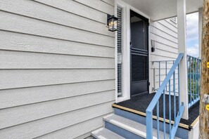 A house with a front porch, a black door, and a blue staircase.