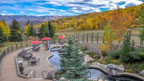 Un espace patio avec des sièges d’extérieur, une petite piscine et une vue sur un paysage montagneux.