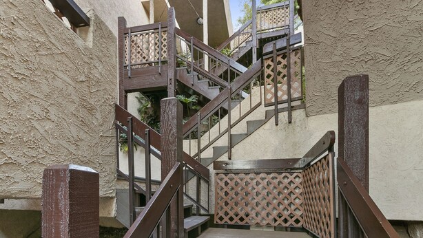 A set of wooden stairs with a lattice handrail, leading to an upper level. - C54: 2 Bedroom, 2 Bath Condo, Balcony with Views, Pool, BBQ (Avalon)