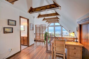Enjoy ocean views from the large window in this cozy attic room with a high ceiling and exposed beams.