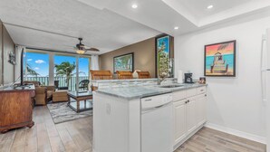A spacious kitchen with a central island, a dining area with a view, and a ceiling fan. - Beach Condo/ Island Beach Resort/No Cleaning Fee/ Condo 308 (Jensen Beach)