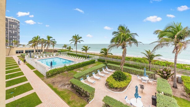 A resort with a swimming pool, palm trees, and a view of the beach. - Beach Condo/ Island Beach Resort/No Cleaning Fee/ Condo 308 (Jensen Beach)