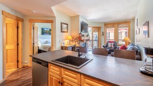 A modern kitchen with a built-in dishwasher, wooden cabinets, and a large island with a sink.