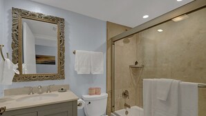 Un baño con un espejo grande y decorativo, un lavamanos, un inodoro y una zona de ducha.