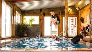 Una piscina interior con paredes de madera y suelo de baldosas.