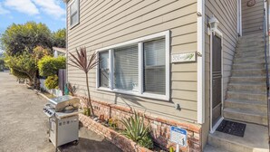 A two-story house with a garage, a grill outside, and a sign indicating a pet-friendly policy. - 315E Lower: Spacious, Remodeled, Ground Level Duplex, Quiet Street, WIFI - 315 E (Avalon)