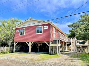 Un bâtiment rouge avec un porche blanc et un garage fermé.