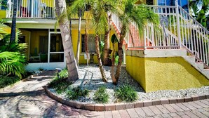 A yellow building with a balcony and a staircase. - Royal Palm Unit 4 4 1,000 sq ft of FUN (Clearwater Beach)