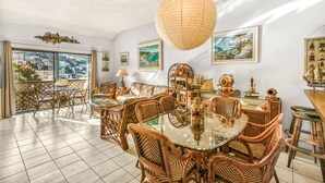 A spacious dining area with wicker furniture, a glass table, and nautical decor. - A23 - Bahia Vista Condo: 2 Bedroom, 1.75 Bath, Pool (Avalon)