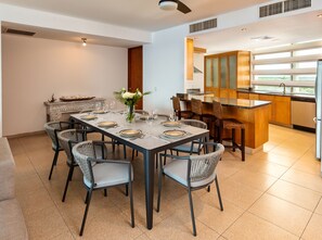 Un comedor moderno con una mesa rectangular dispuesta para seis personas, rodeada de sillas de mimbre.