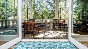 A covered patio with wooden furniture and a patterned rug. - Union Pier Condo with Association Heated Pool. Close to Beach And Downtown! (Union Pier)