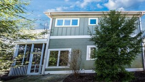 A two-story house with a covered porch, a small garden, and a clear sky. - Union Pier Condo with Association Heated Pool. Close to Beach And Downtown! (Union Pier)