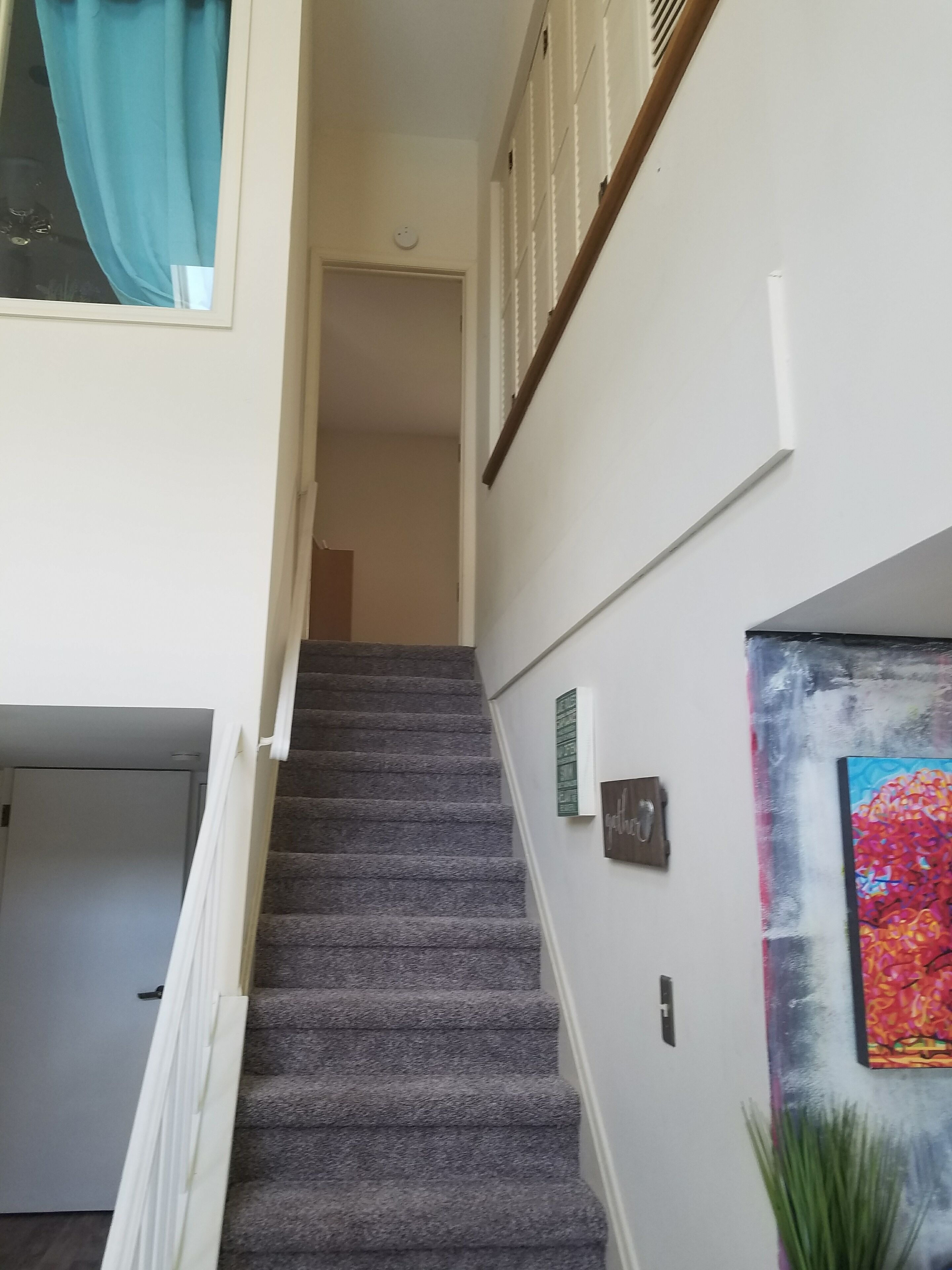 A staircase with carpeted steps leading to a landing.