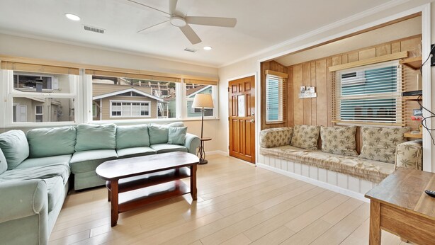 A spacious living room with a light green sectional sofa, a wooden coffee table, and a ceiling fan. - 331D: Quaint Cottage, 3 Blocks from Beach + Open Living Space + Sleeps 8 Tandem (Avalon)