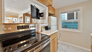 A modern kitchen with stainless steel appliances, wooden cabinets, and a window with a view. - 331D: Quaint Cottage, 3 Blocks from Beach + Open Living Space + Sleeps 8 Tandem (Avalon)