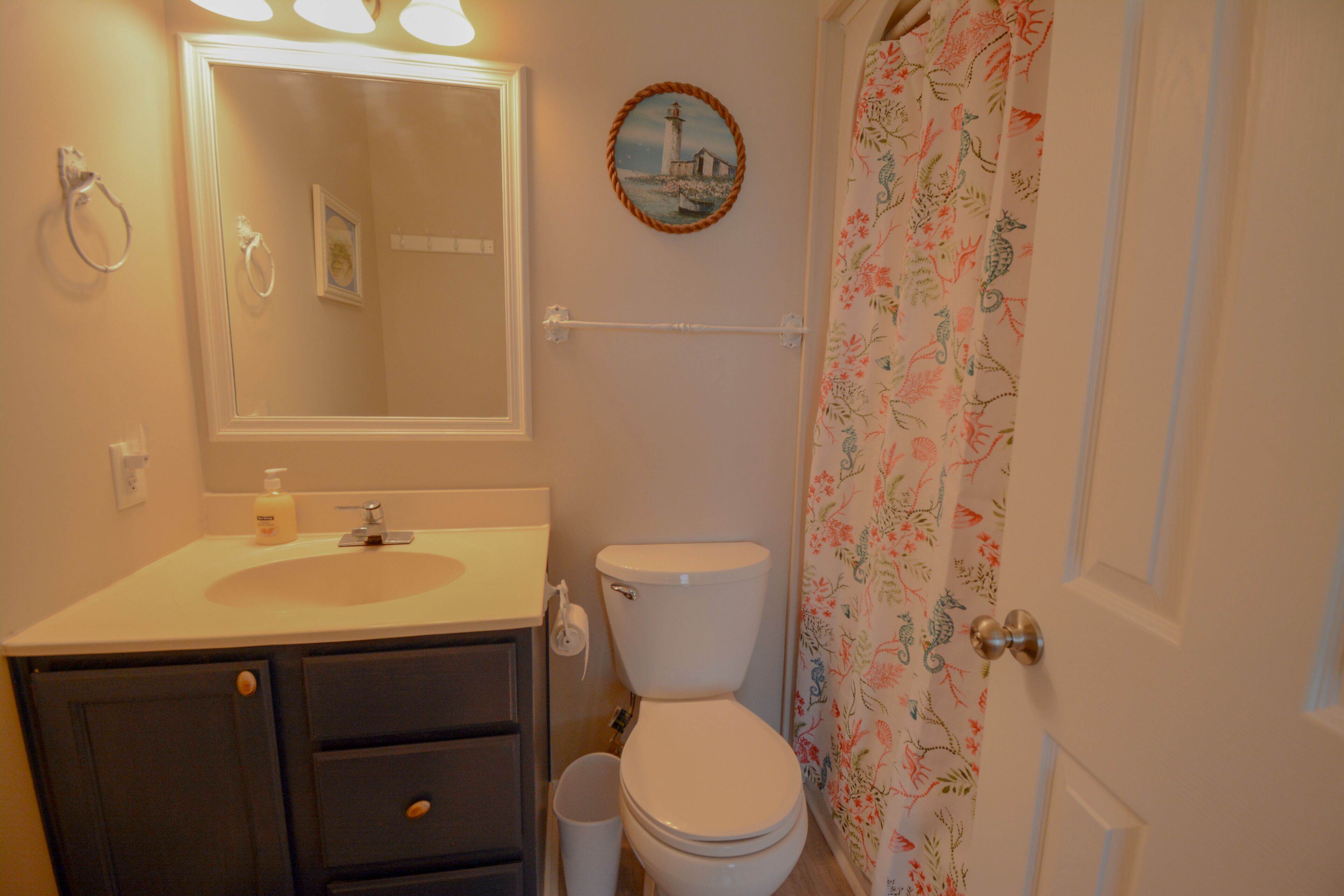 A bathroom with a sink, toilet, and shower curtain.