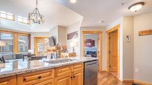 A kitchen with wooden cabinets, a stainless steel dishwasher, and a granite countertop.