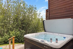 Un bain à remous équipé d’un panneau de commande et sur lequel sont posées deux canettes de bière.