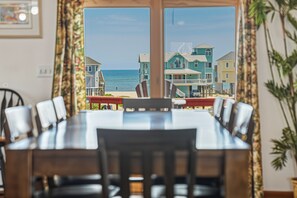 Un área de comedor con vistas a la playa y casas.