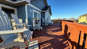 A wooden deck with Adirondack chairs and a wooden railing. -     7BR Coastal Escape ,Ocean and Sound Views, Pool, Hot Tub & Pet Friendly (Rodanthe)