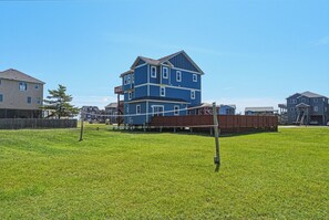 A multi-story residential building with a flat roof and a fenced backyard.