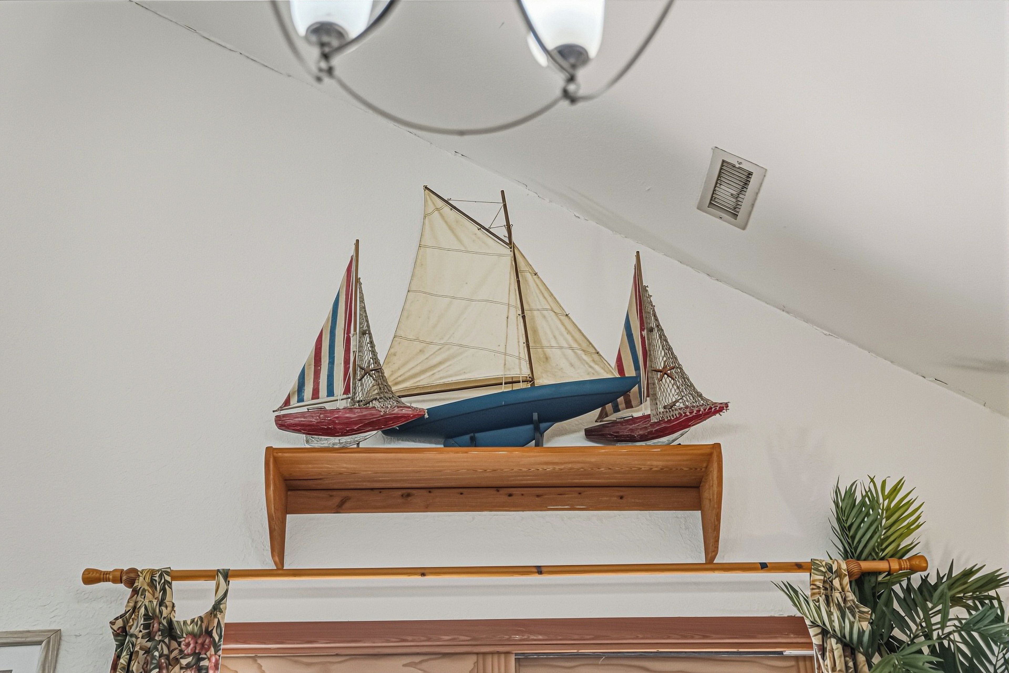 A model sailboat on a wooden shelf.