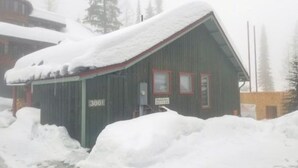 Ein mit Schnee bedecktes Gebäude mit der Nummer 3861 an der Seite, umgeben von Schnee.