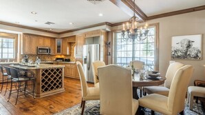 A spacious kitchen with wooden cabinets, a central island, and a dining area with four chairs.
