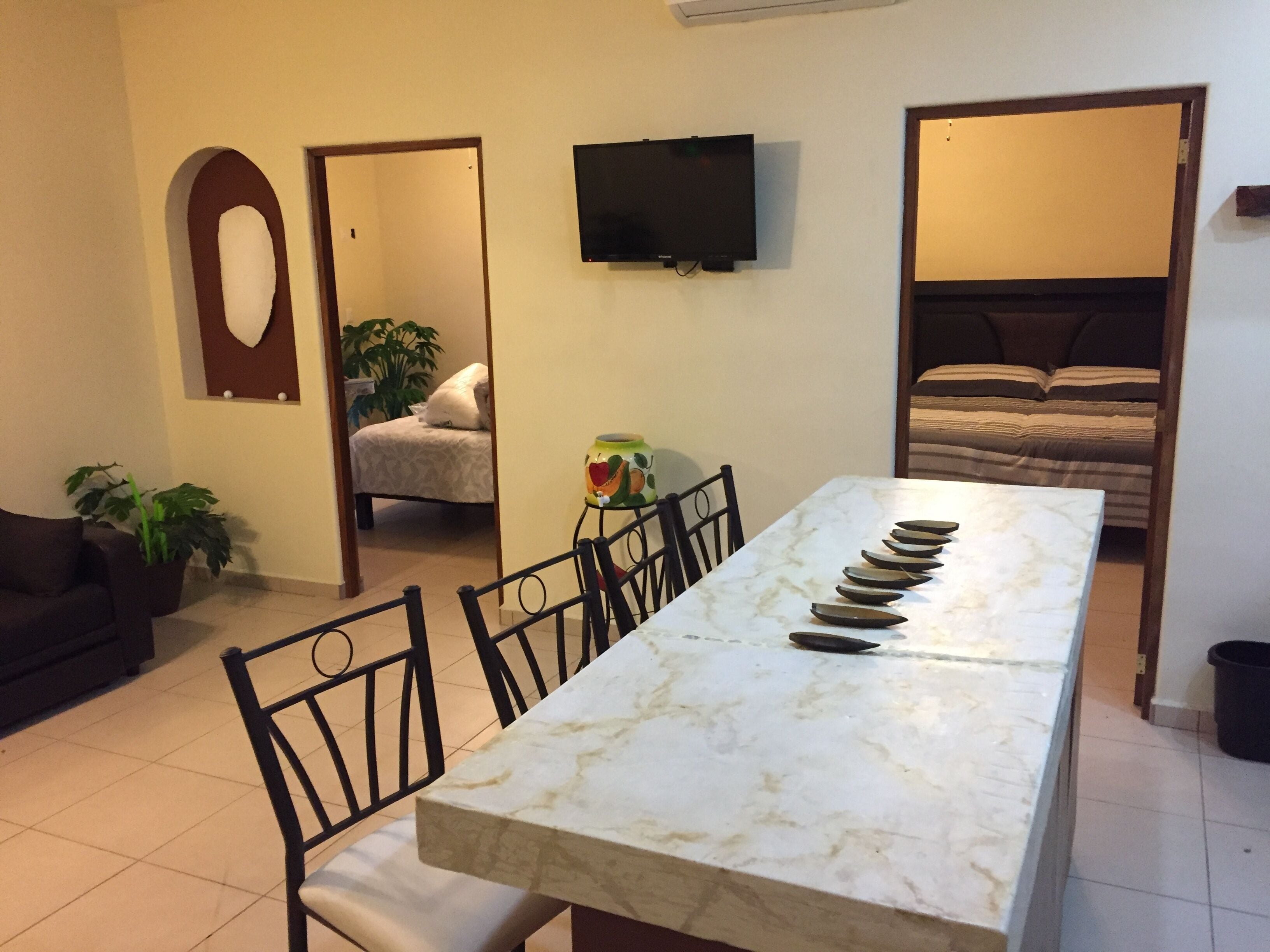 View entering condo. Kitchen Island,  bar, entrances to bedrooms, tv