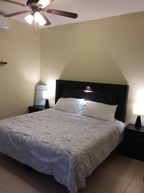 A neatly made bed with a patterned bedspread, a ceiling fan, and a bedside lamp on a nightstand. - 2bed Bucerias “Tortuga” at Tres Soles Hideaway, Pool, near Beach and Downtown (Bucerías)