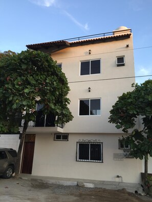 A multi-story building with a flat roof, multiple windows, and a small balcony. - 2bed Bucerias “Tortuga” at Tres Soles Hideaway, Pool, near Beach and Downtown (Bucerías)