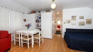 Um espaço compacto com área de jantar, sofá e estante.