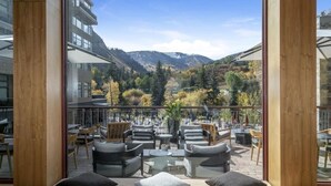 A terrace with outdoor seating, a mountain view, and a glass wall. - CRBC Remodeled 2024 Resort & Spa, Ski in out, Ski Valet, Health Club, Hot Tubs (Avon)