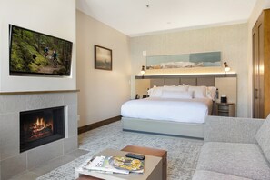 Ein Hotelzimmer mit einem Bett, einem Kamin, einer Couch und einem Fernseher.