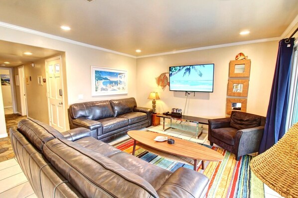 A living room with a sofa set, a coffee table, a TV, and a patterned rug. - Beach View • 25Min2Disney • W/D • Parking • Bikes (Newport Beach)