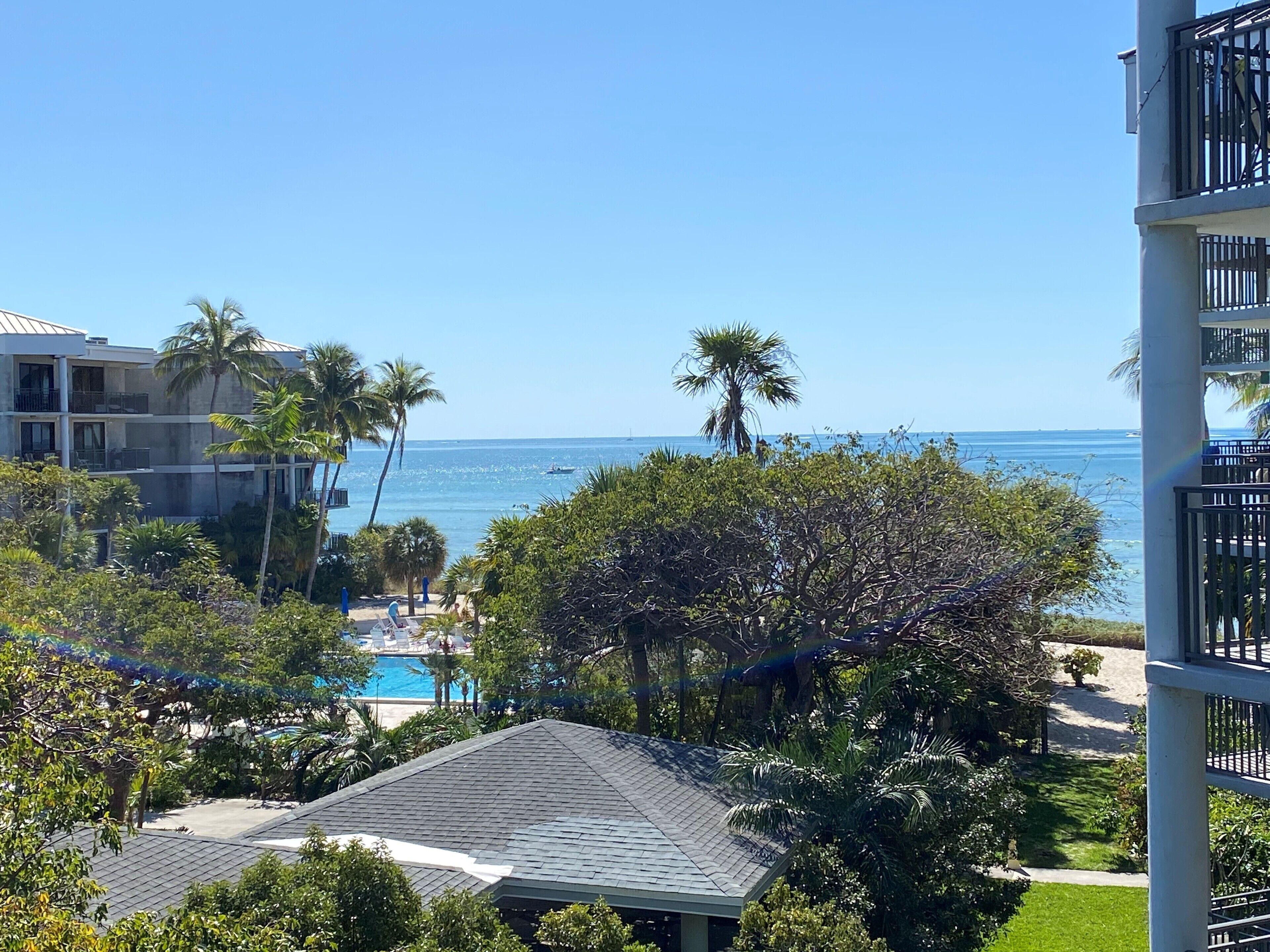 Ein Resort mit Pool, Palmen und Meerblick.