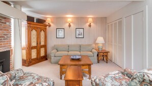 A living room with a sofa, a wooden coffee table, a fireplace, and a brick wall. - 5-Min Walk to Warm Springs Ski Lifts (Ketchum)