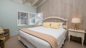 A bedroom with a large bed, two bedside tables, a nightstand, a window with blinds, and a ceiling with exposed beams. - 5-Min Walk to Warm Springs Ski Lifts (Ketchum)